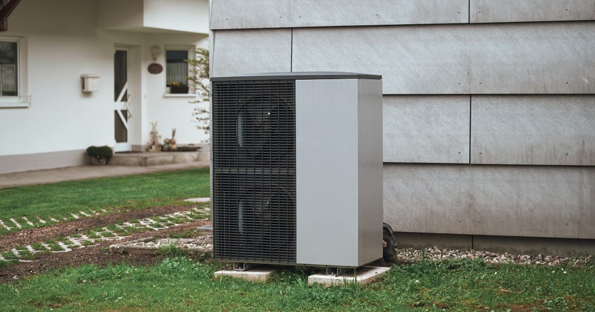 Een warmtepomp die buitenshuis in de tuin is geplaatst