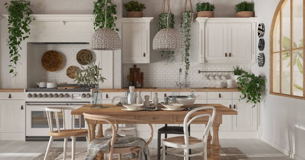 Een keuken in landelijke stijl: witte keukenkasten, een moderne en ruime witte oven, een gezellige houten tafel en veel groen.